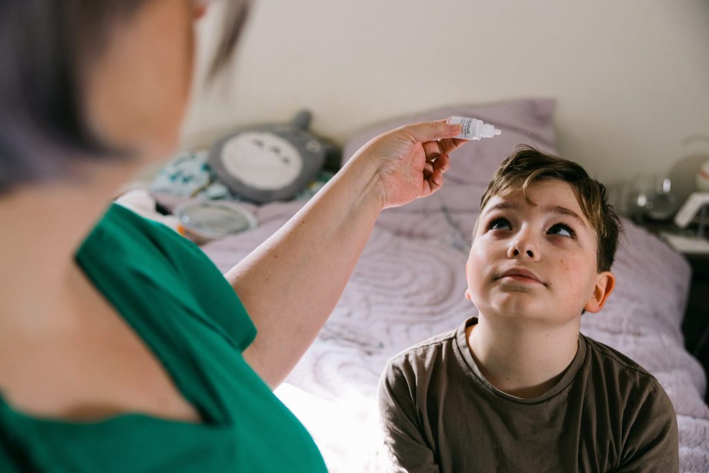 A child receiving eyedrops to treat myopia