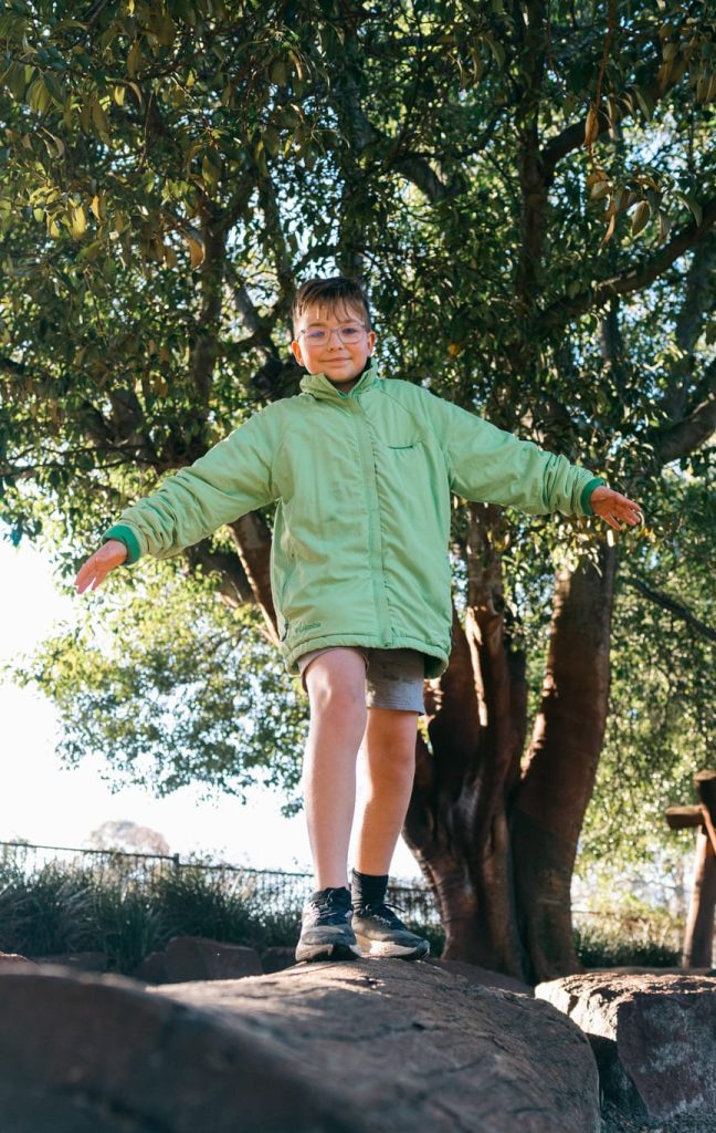 Lincoln, who wears glasses, playing outdoors.